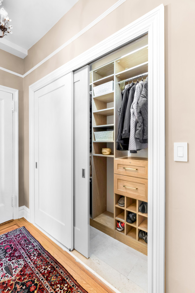 Large contemporary gender-neutral storage and wardrobe in New York with flat-panel cabinets, dark wood cabinets, porcelain floors and beige floor.