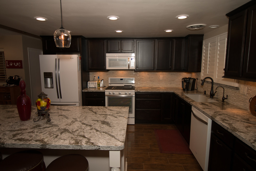 Open concept kitchen - mid-sized transitional l-shaped porcelain tile open concept kitchen idea with an undermount sink, flat-panel cabinets, dark wood cabinets, quartz countertops, beige backsplash, glass sheet backsplash, white appliances and an island