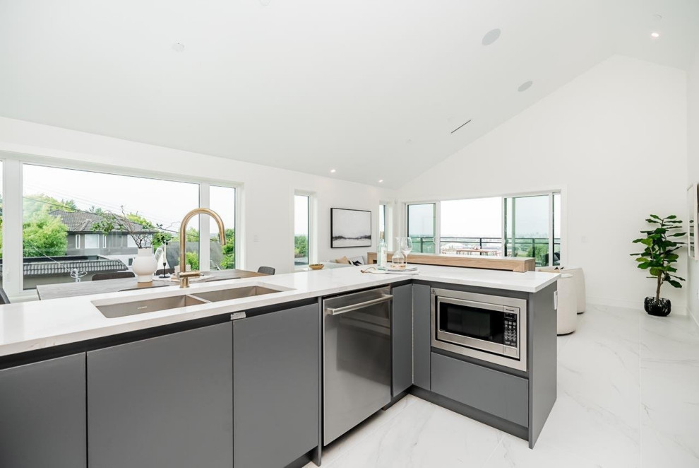 Kitchen pantry - mid-sized transitional u-shaped ceramic tile, multicolored floor and vaulted ceiling kitchen pantry idea in Vancouver with an undermount sink, flat-panel cabinets, gray cabinets, quartzite countertops, white backsplash, ceramic backsplash, stainless steel appliances, an island and white countertops