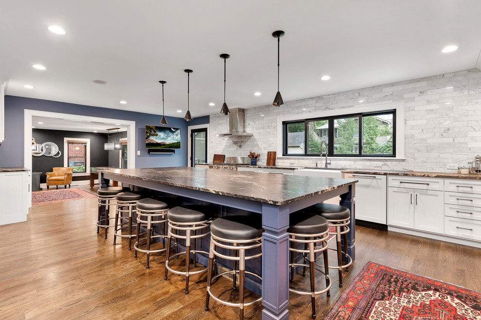 Design ideas for a large traditional l-shaped open plan kitchen in Columbus with a farmhouse sink, shaker cabinets, white cabinets, granite benchtops, white splashback, marble splashback, stainless steel appliances, medium hardwood floors, with island, brown floor and multi-coloured benchtop.
