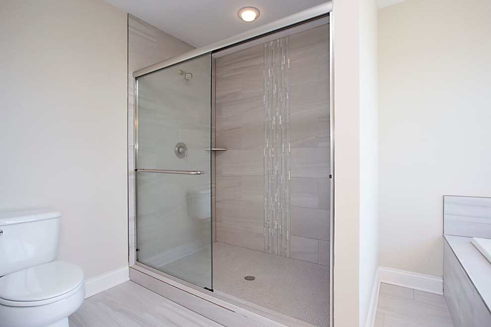 Large transitional master beige tile and porcelain tile porcelain tile and beige floor drop-in bathtub photo in Chicago with recessed-panel cabinets, dark wood cabinets, a two-piece toilet, beige walls, an undermount sink, granite countertops and a hinged shower door