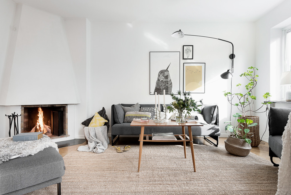 Design ideas for a mid-sized scandinavian formal living room in Gothenburg with white walls, medium hardwood floors, a corner fireplace, a concrete fireplace surround, no tv and brown floor.