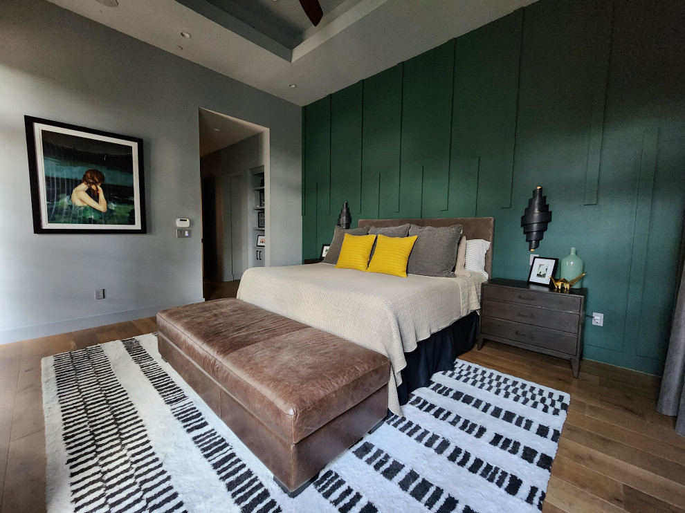 Cette image montre une grande chambre parentale minimaliste avec un mur vert, parquet clair et un plafond décaissé.