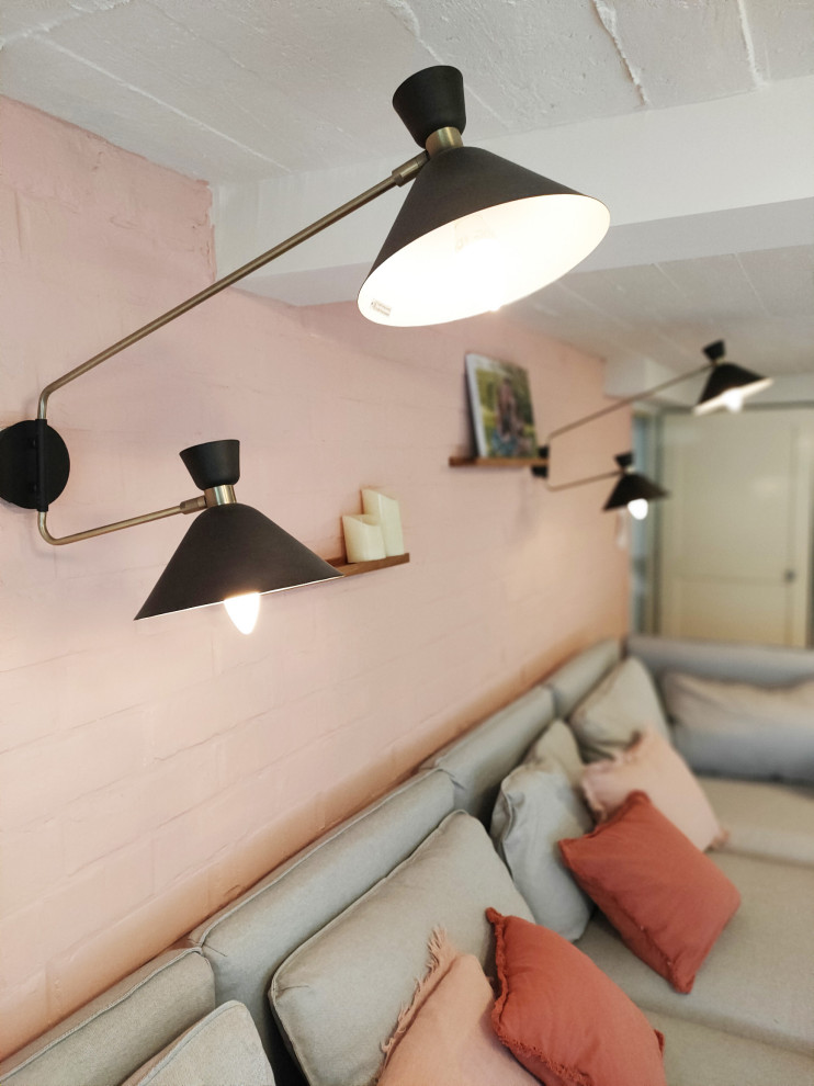 Modern inredning av en mellanstor källare ovan mark, med rosa väggar och laminatgolv