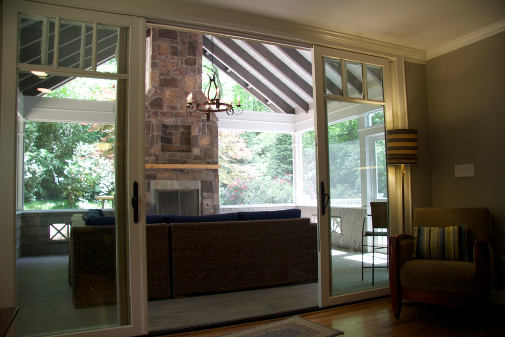 This is an example of a mid-sized contemporary sunroom in Atlanta with medium hardwood floors, a standard fireplace, a stone fireplace surround, a standard ceiling and brown floor.