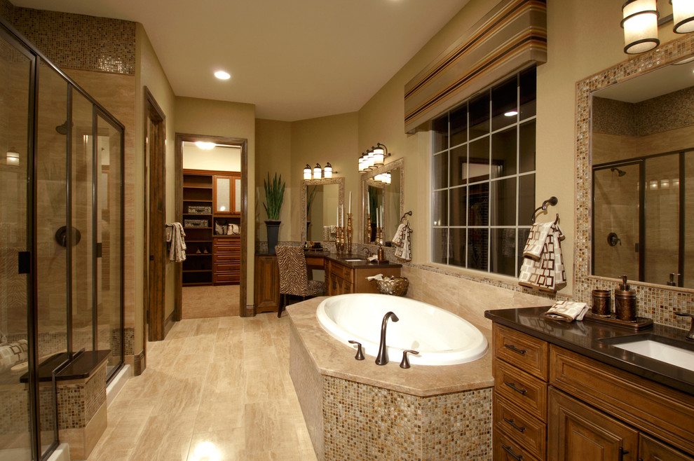 Photo of a mediterranean bathroom in Denver with a drop-in tub, an undermount sink, brown walls, beige floor and brown benchtops.