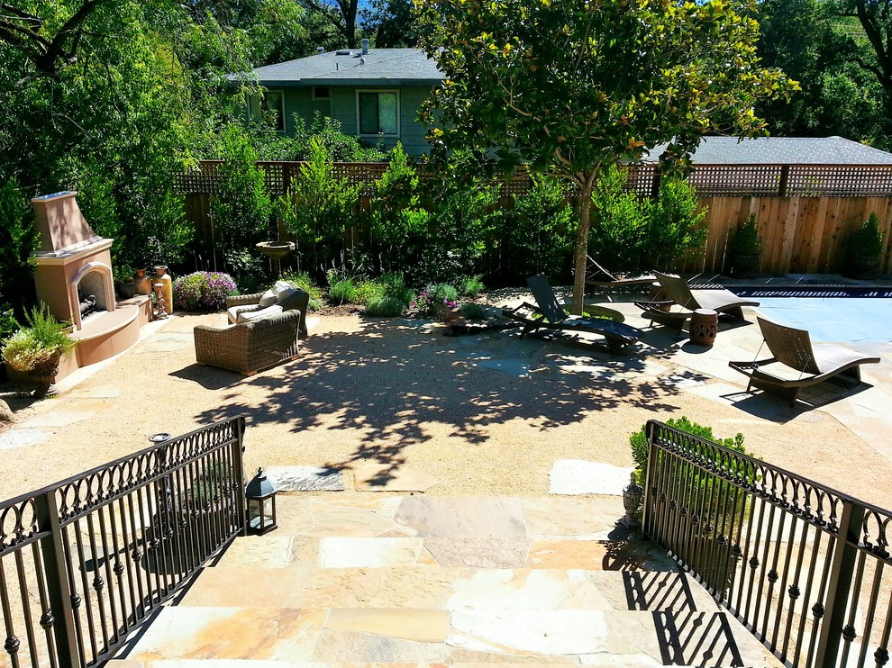 This is an example of a mid-sized contemporary courtyard patio in San Francisco with a fire feature and decomposed granite.