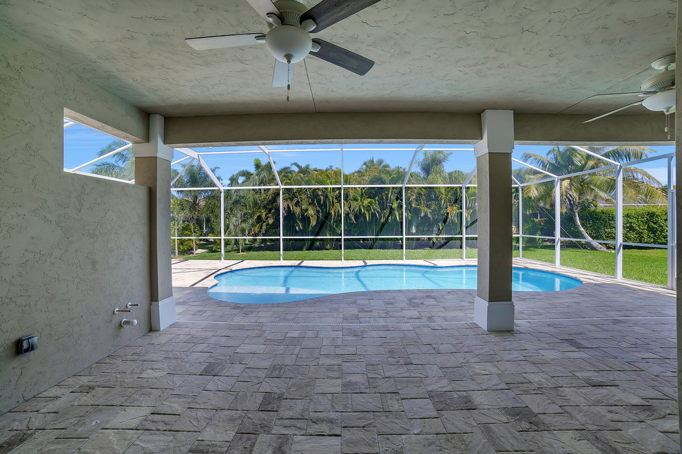 Mid-sized transitional backyard stone patio photo with a roof extension
