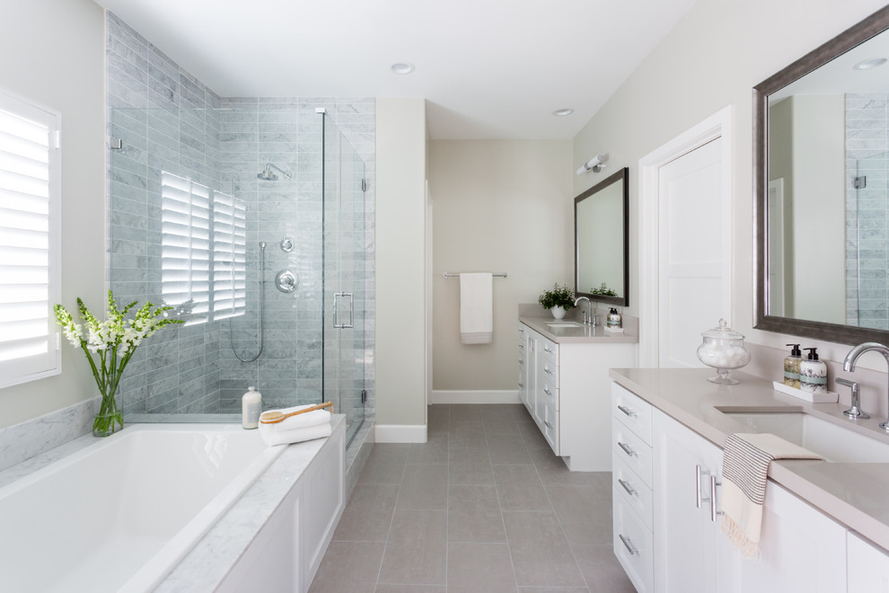 Photo of a large transitional master bathroom in Los Angeles with shaker cabinets, white cabinets, a drop-in tub, beige tile, ceramic tile, grey walls, porcelain floors, an undermount sink, engineered quartz benchtops and grey floor.