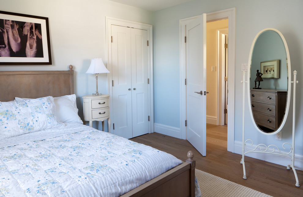Photo of a traditional kids' room for girls in New York with blue walls and medium hardwood floors.