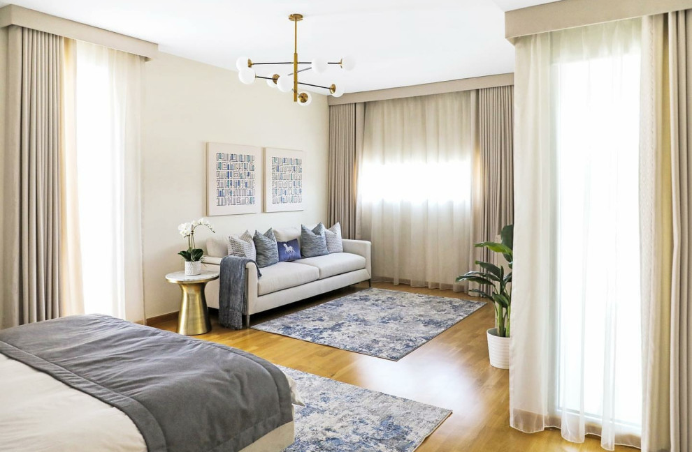 This is an example of a mid-sized contemporary master bedroom in Other with beige walls and light hardwood floors.