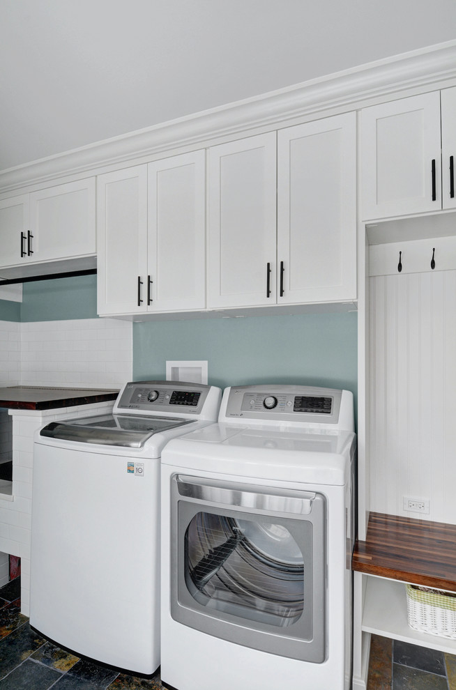 Design ideas for a traditional galley utility room in Chicago with raised-panel cabinets, white cabinets, laminate benchtops and a side-by-side washer and dryer.