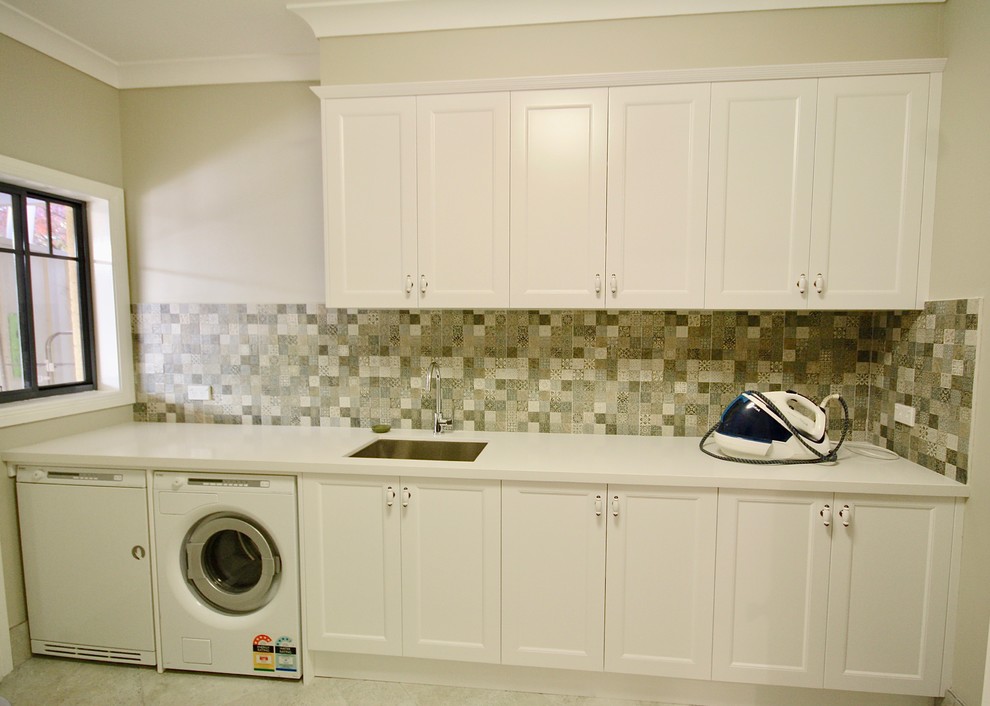 Mid-sized transitional single-wall dedicated laundry room in Sydney with an undermount sink, shaker cabinets, white cabinets, quartz benchtops, beige walls, porcelain floors, a side-by-side washer and dryer and beige floor.