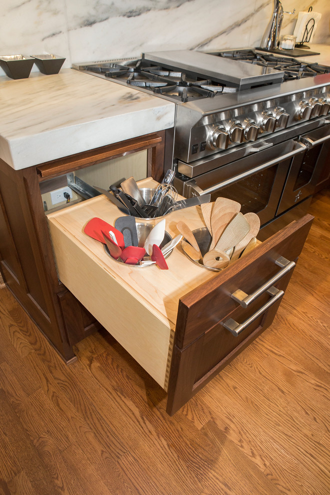 Inspiration for a huge transitional l-shaped medium tone wood floor enclosed kitchen remodel in Chicago with an undermount sink, flat-panel cabinets, medium tone wood cabinets, marble countertops, white backsplash, stone slab backsplash, stainless steel appliances and an island