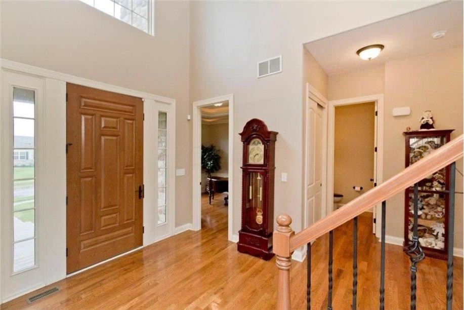This is an example of a large traditional front door in Columbus with beige walls, light hardwood floors, a single front door and a light wood front door.