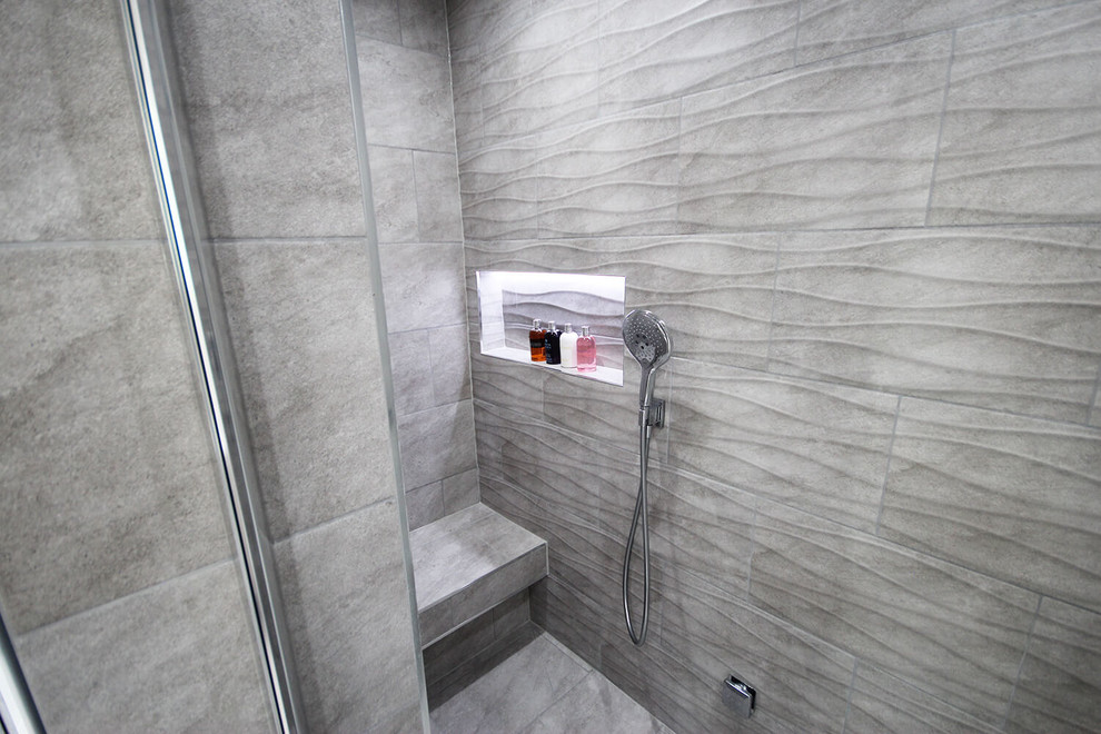 Design ideas for a mid-sized contemporary master bathroom in Surrey with a drop-in tub, a curbless shower, a wall-mount toilet, gray tile, porcelain tile, grey walls, porcelain floors, an undermount sink, grey floor and a hinged shower door.