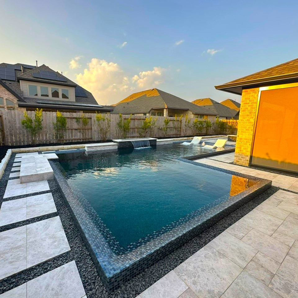 This is an example of a modern l-shaped pool in Houston with natural stone pavers.