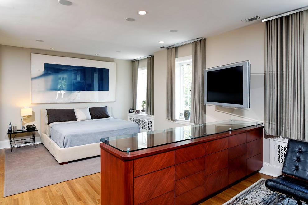 This is an example of a contemporary bedroom in DC Metro with grey walls and light hardwood floors.
