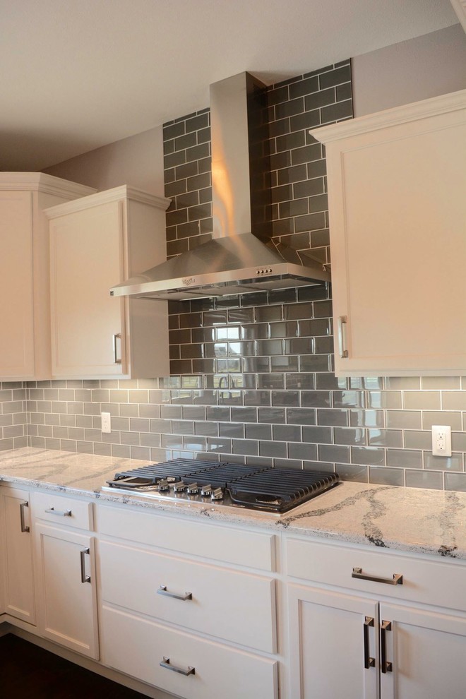 Example of a large transitional l-shaped dark wood floor open concept kitchen design with an undermount sink, shaker cabinets, white cabinets, granite countertops, gray backsplash, porcelain backsplash, stainless steel appliances and an island