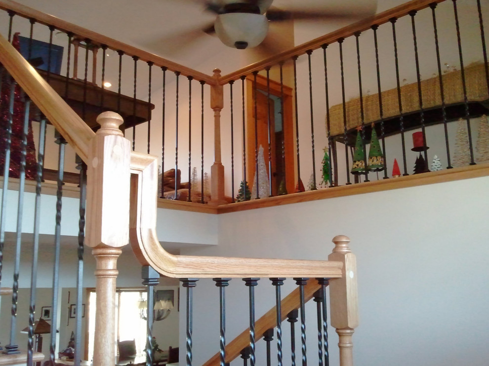 Imagen de escalera en U de estilo americano extra grande con escalones de madera, contrahuellas de madera pintada y barandilla de varios materiales
