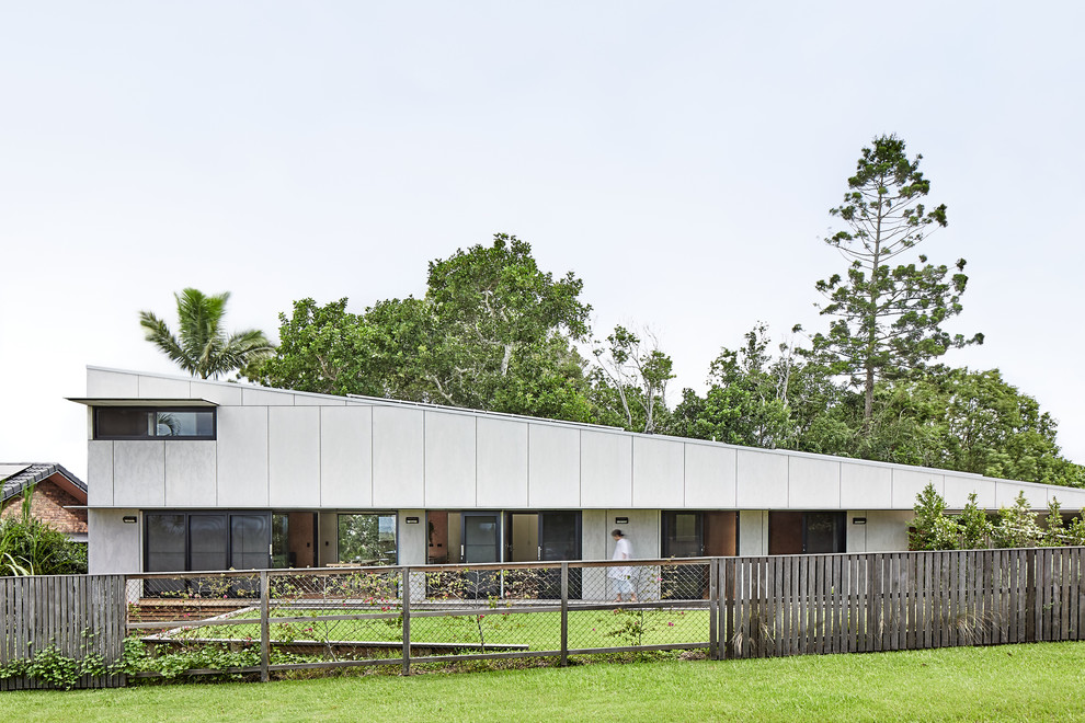 Inspiration for a mid-sized contemporary two-storey grey house exterior in Other with concrete fiberboard siding, a flat roof and a metal roof.