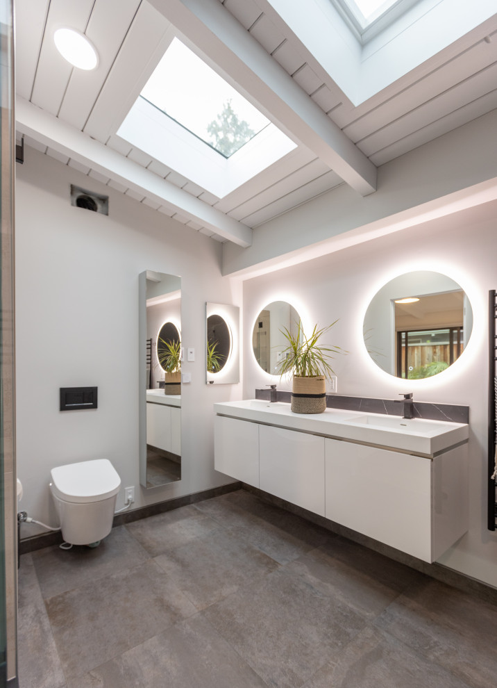 Design ideas for a midcentury bathroom in San Francisco with flat-panel cabinets, white cabinets, white walls, an integrated sink, grey floor, white benchtops, a double vanity, a floating vanity, exposed beam, timber and vaulted.