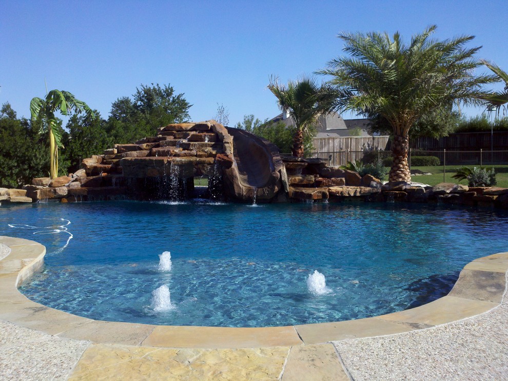 This is an example of a mid-sized traditional backyard custom-shaped pool in Houston with concrete slab and a hot tub.