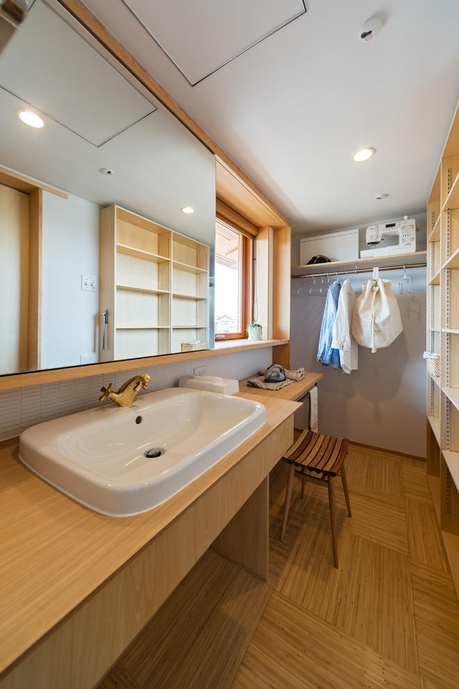 Design ideas for an asian single-wall utility room in Other with a drop-in sink, open cabinets, light wood cabinets, wood benchtops and white walls.