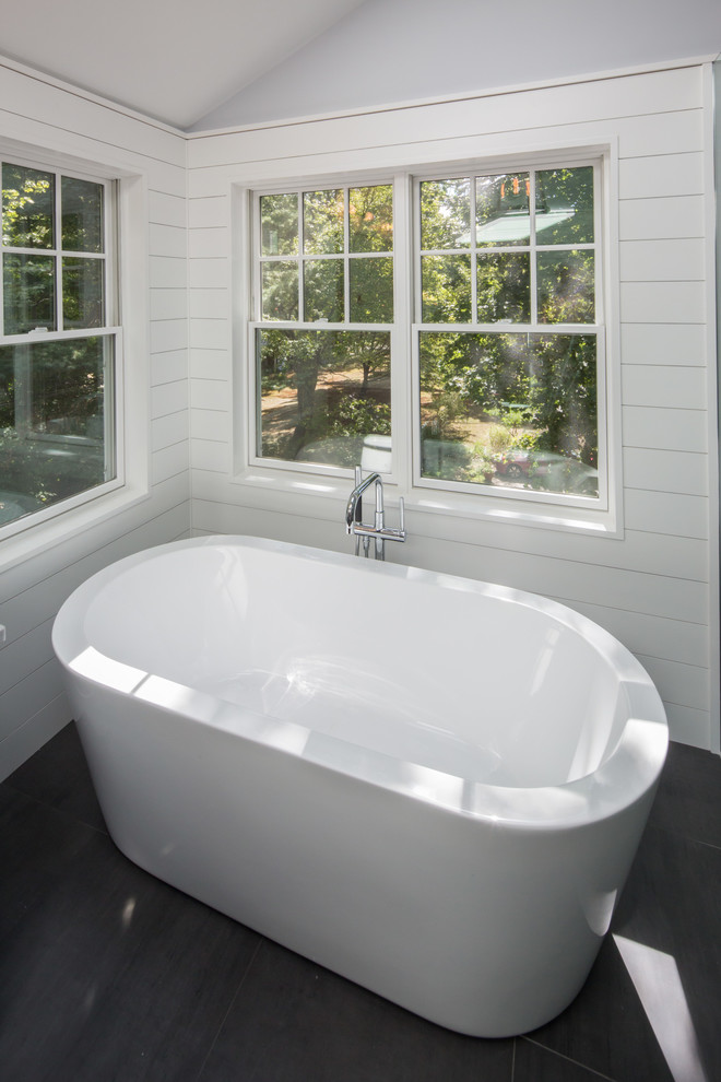 Large transitional master gray tile and porcelain tile porcelain tile freestanding bathtub photo in Boston with recessed-panel cabinets, gray cabinets, a one-piece toilet, blue walls, an undermount sink and quartzite countertops