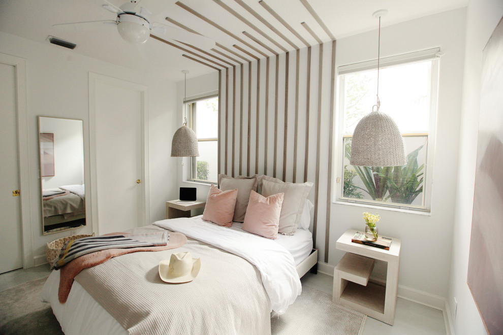 This is an example of a beach style guest bedroom in Miami with laminate floors and wood walls.