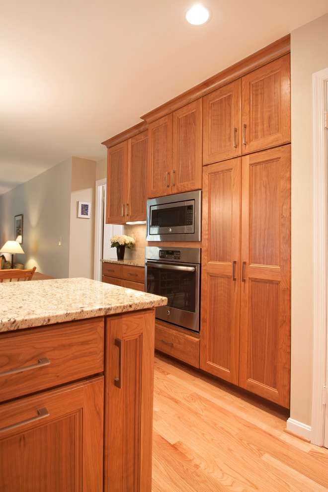 Kitchen - traditional kitchen idea in DC Metro with raised-panel cabinets, light wood cabinets, granite countertops, beige backsplash, ceramic backsplash, stainless steel appliances and a peninsula