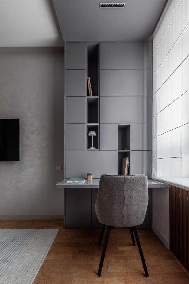 Идея дизайна: рабочее место среднего размера в современном стиле с серыми стенами, пробковым полом и встроенным рабочим столом
