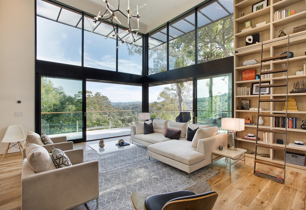 This is an example of a contemporary living room in San Francisco with a library and light hardwood floors.