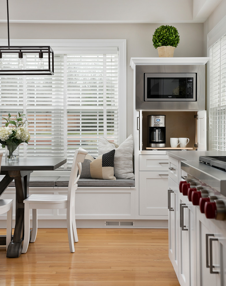 Example of a large transitional light wood floor open concept kitchen design in Chicago with an undermount sink, shaker cabinets, white cabinets, quartz countertops, gray backsplash, marble backsplash, stainless steel appliances and an island