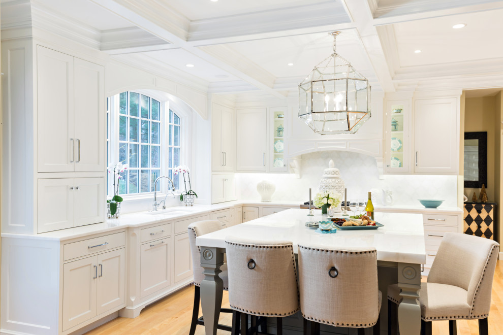 This is an example of a large traditional u-shaped eat-in kitchen in Boston with an undermount sink, beaded inset cabinets, white cabinets, quartzite benchtops, white splashback, marble splashback, panelled appliances, light hardwood floors, with island, white benchtop and coffered.