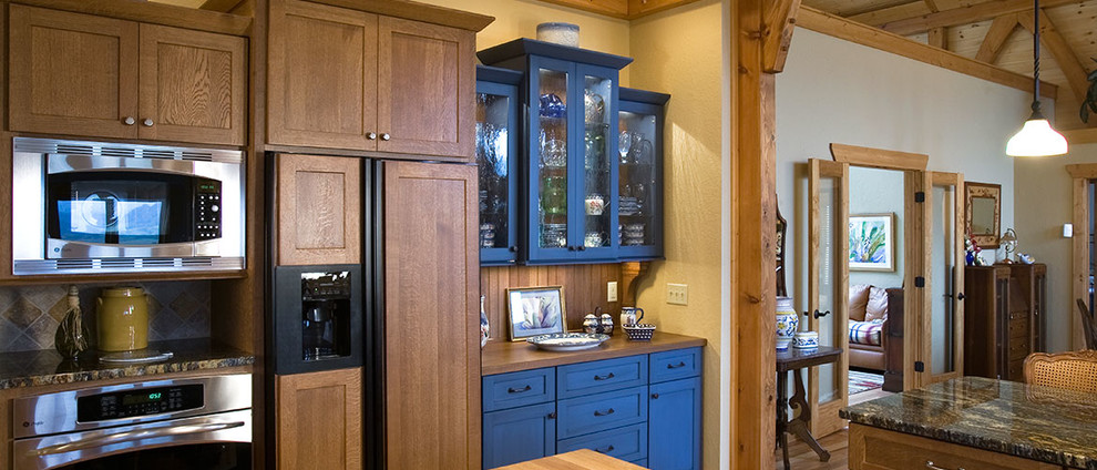 Large mountain style u-shaped medium tone wood floor eat-in kitchen photo with a drop-in sink, dark wood cabinets, marble countertops, beige backsplash, ceramic backsplash, stainless steel appliances and an island