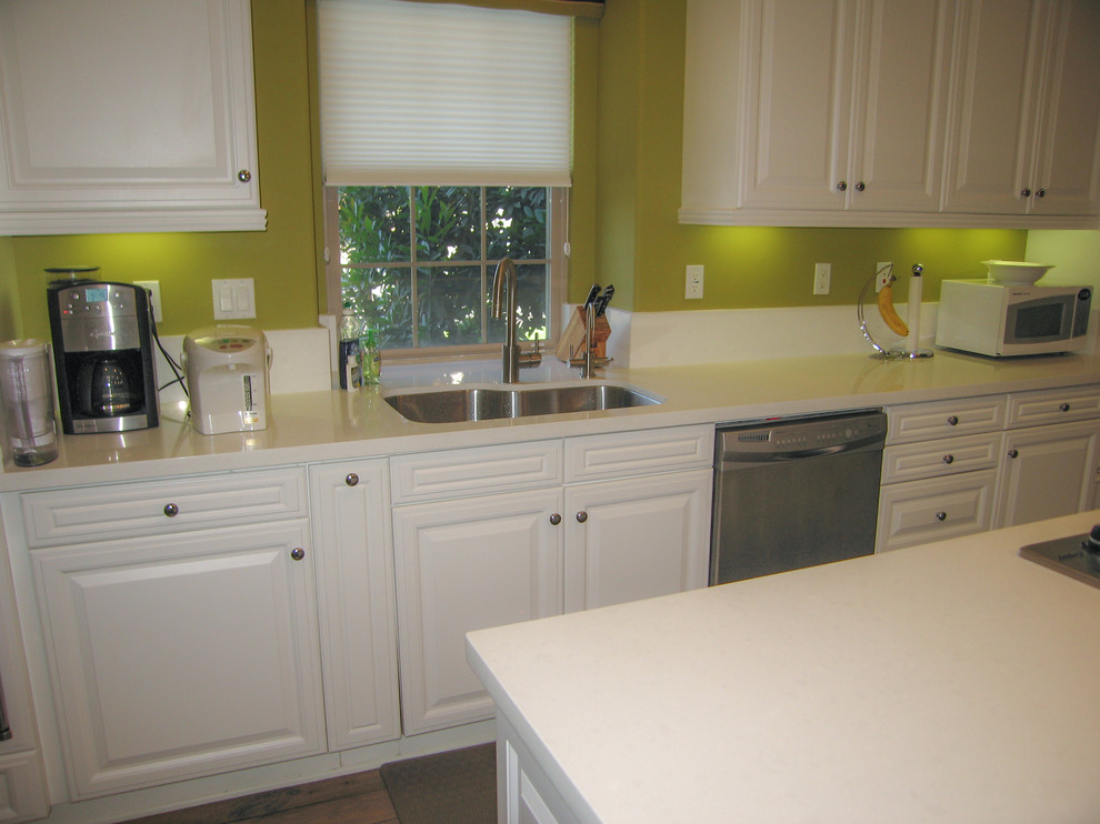 Inspiration for a mid-sized contemporary galley light wood floor open concept kitchen remodel in Orange County with an undermount sink, raised-panel cabinets, white cabinets, quartzite countertops, green backsplash, stone slab backsplash, stainless steel appliances and an island