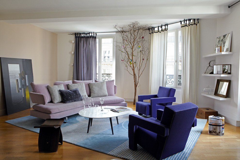Inspiration for a mid-sized contemporary enclosed family room in Paris with no tv, pink walls and light hardwood floors.
