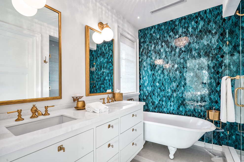 Design ideas for an expansive world-inspired grey and teal wet room bathroom in Miami with flat-panel cabinets, white cabinets, a claw-foot bath, a one-piece toilet, blue tiles, mosaic tiles, white walls, a submerged sink, marble worktops, grey floors, a hinged door, white worktops, double sinks and a floating vanity unit.