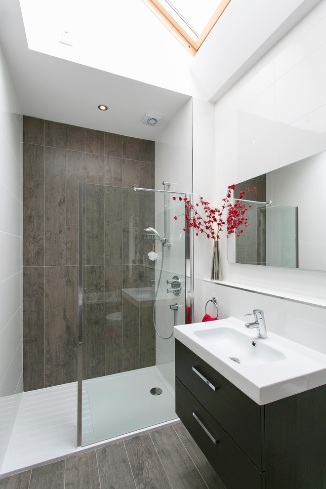 This is an example of a mid-sized contemporary wet room bathroom in Dublin with flat-panel cabinets, black cabinets, brown tile and brown walls.