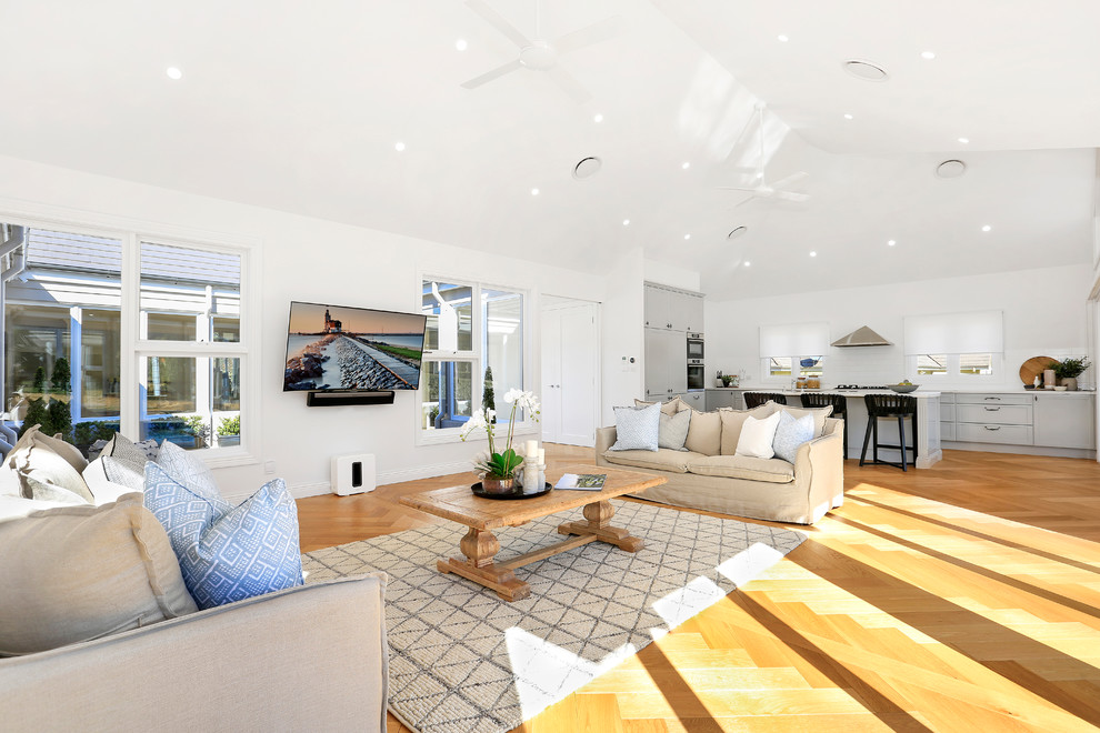 Inspiration for an expansive country open concept living room in Sydney with light hardwood floors and a wall-mounted tv.