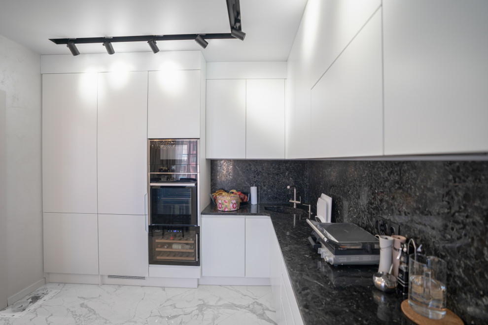 Immagine di una cucina minimal di medie dimensioni con lavello sottopiano, ante lisce e ante bianche