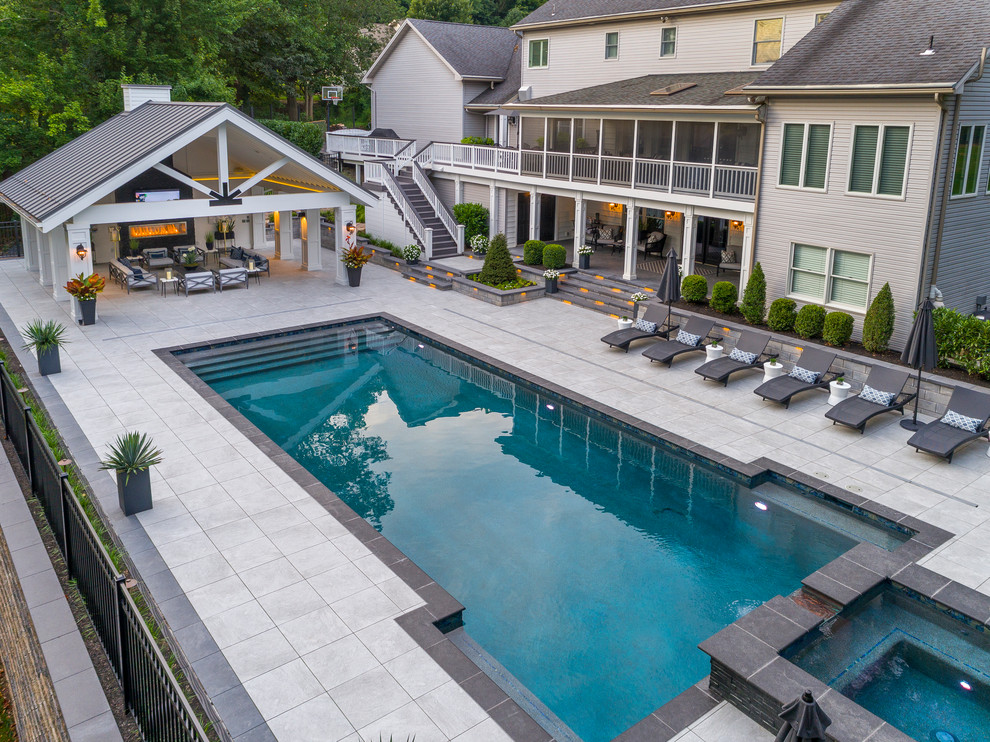 Example of a large transitional backyard concrete paver and rectangular lap pool house design