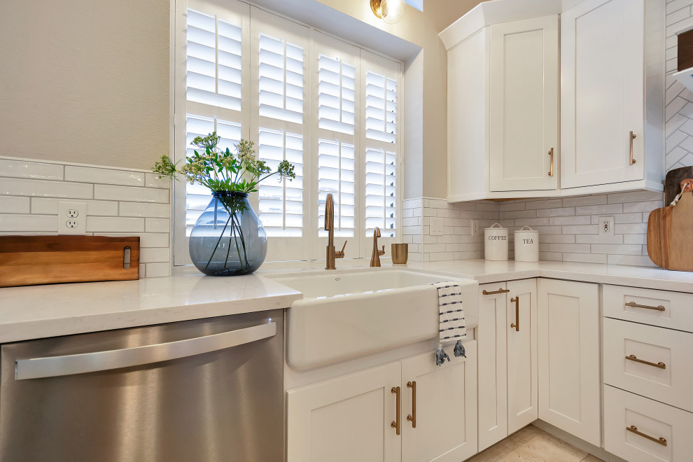 Example of a large transitional u-shaped open concept kitchen design in Phoenix with a farmhouse sink, shaker cabinets, white cabinets, quartz countertops, white backsplash, subway tile backsplash, stainless steel appliances, an island and white countertops