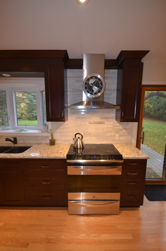Example of a mid-sized transitional galley medium tone wood floor and brown floor eat-in kitchen design in Ottawa with recessed-panel cabinets, dark wood cabinets, granite countertops, gray backsplash, stainless steel appliances, a double-bowl sink, porcelain backsplash, a peninsula and beige countertops