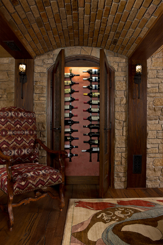 This is an example of a large traditional wine cellar in Detroit with dark hardwood floors, storage racks and brown floor.