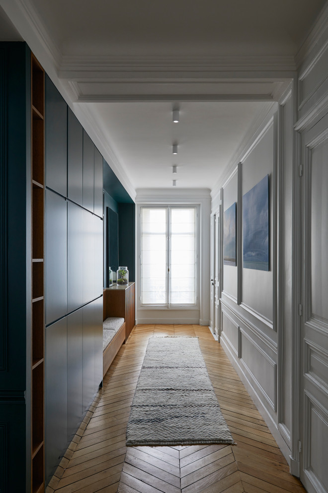 Großes Modernes Foyer mit grüner Wandfarbe, hellem Holzboden, Doppeltür, weißer Haustür, braunem Boden und vertäfelten Wänden in Paris