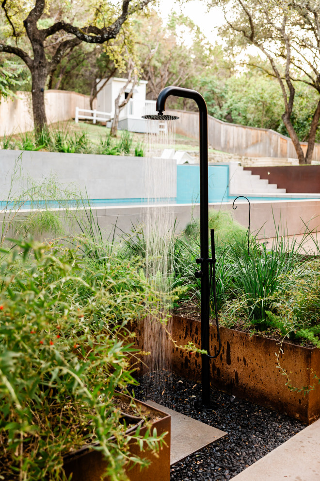 Large backyard tile and rectangular lap hot tub photo in Austin