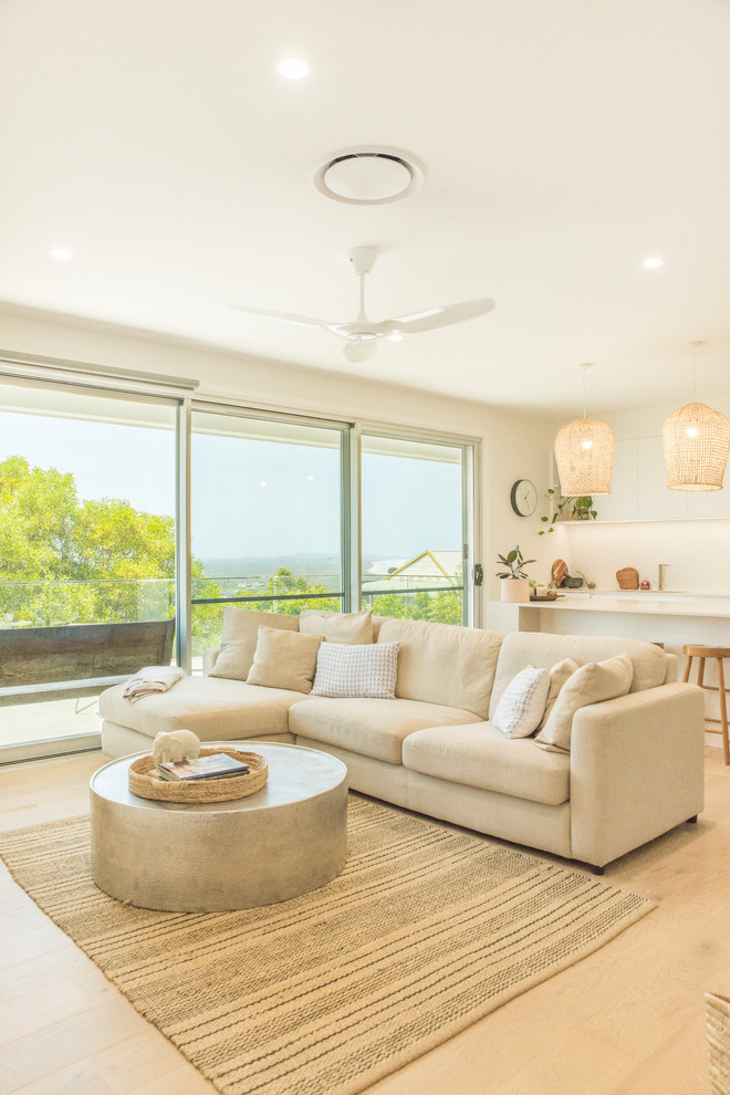 Photo of a large contemporary open concept living room in Sunshine Coast with white walls and light hardwood floors.