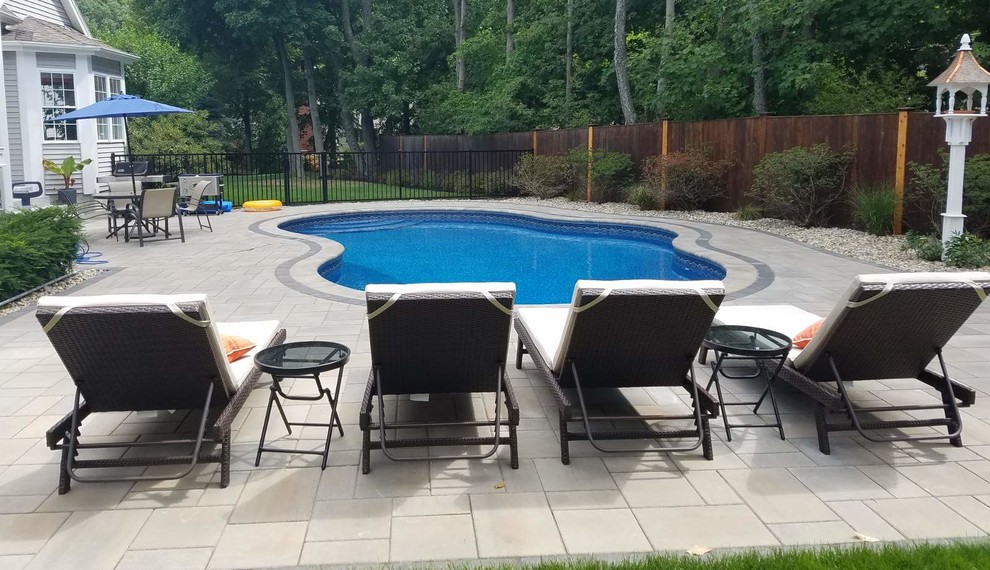 Photo of a mid-sized modern backyard custom-shaped natural pool in Boston with concrete pavers.